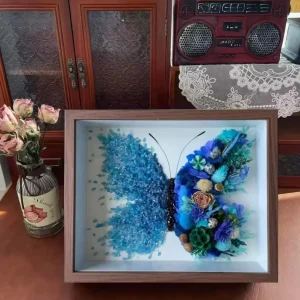 Close-up of sea blue crystals and pressed flowers in butterfly shadow box