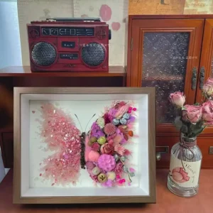 Close-up of strawberry crystals and pressed flowers in butterfly shadow box